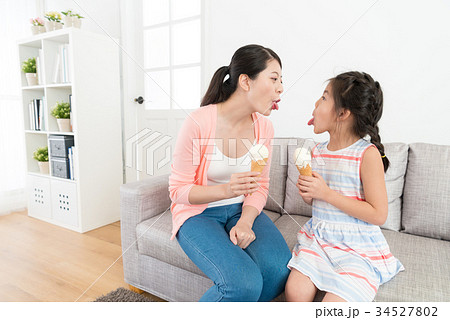 mother and girl showing tongues to each other mother and girl showing tongues to each other 34527802