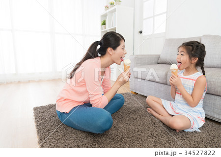 happy pretty mother sitting on living room floor happy pretty mother sitting on living room floor 34527822