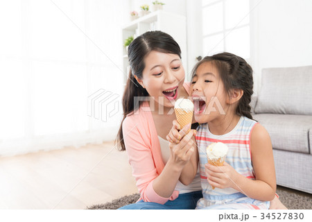 mother with daughter eating ice cream together 34527830
