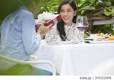 romantic boyfriend is giving a present for his girfiend in a restaurant 34531009