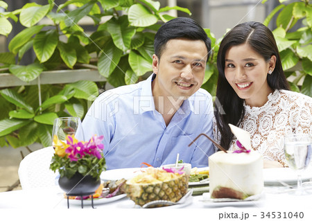 a happy couple is sitting and smiling when having lunch in a restaurant a happy couple is sitting and smiling when having lunch in a restaurant 34531040