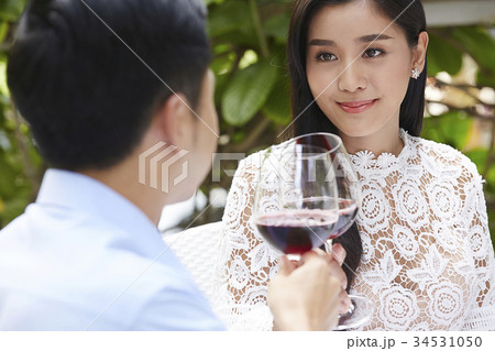 a happy beautiful woman is clinking glasses of wine with her boyfriend a happy beautiful woman is clinking glasses of wine with her boyfriend 34531050