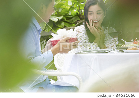 An Asian woman is surprised because of her boyfriend's gift. 34531066