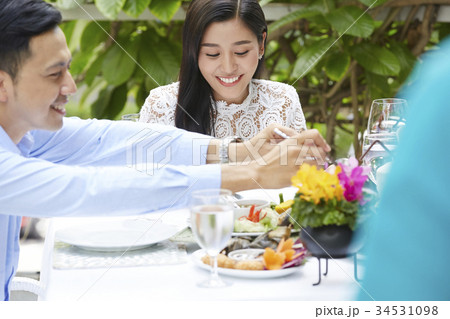 An Asian man is taking care of his girlfriend in a meal. 34531098