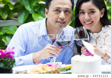 The happy couple is cheering by glasses of red wine in the special day The happy couple is cheering by glasses of red wine in the special day 34531121