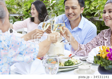 The man is smilling and cheering with every people at a party 34531141