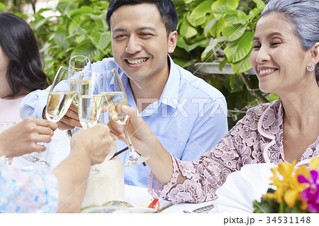 The man and his mother are holding glasses of wine to cheer up 34531148