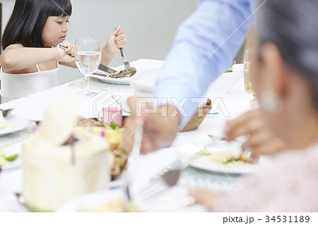 an adorable girl is cutting food in plate with fork and knife in a restaurant an adorable girl is cutting food in plate with fork and knife in a restaurant 34531189