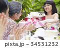 an adorable girl is giving gifts to her grandmother in her anniversary 34531232