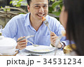a handsome man is smiling and eating with his wife in a restaurant 34531234