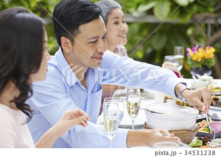 a luxurious man is smiling and sharing food for his wife at a party in a restaurant 34531238