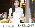 a woman with floral shirt is smiling and eating in a luxurious restaurant 34531247