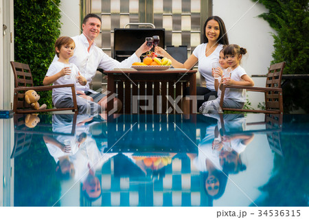 Family take dinner together at the pool Family take dinner together at the pool 34536315