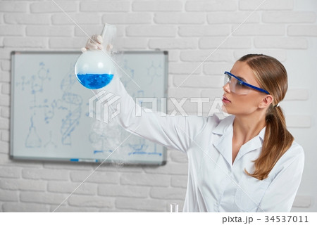 Young woman analyzes the blue chemical liquid 34537011
