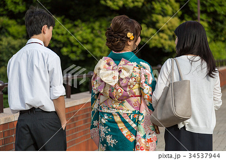 振袖を着た女性と家族の後姿 振袖を着た女性と家族の後姿 34537944