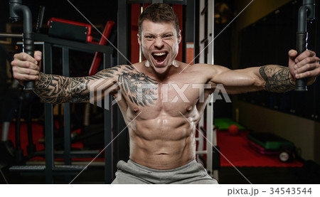 Strong and handsome athletic young tattoo man with muscles 34543544