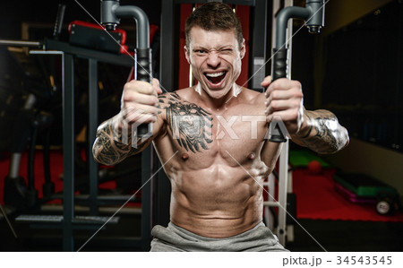 Strong and handsome athletic young tattoo man with muscles Strong and handsome athletic young tattoo man with muscles 34543545