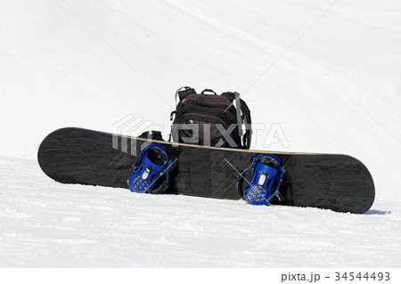 Snowboard and backpack on ski slope Snowboard and backpack on ski slope 34544493
