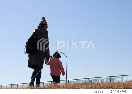 手をつなぐお母さんと子供の後ろ姿の写真素材