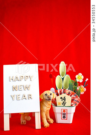 戌年 年賀状素材 赤色 Happy New Year A型看板 門松 犬の置物 縦位置の写真素材