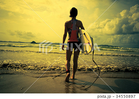 Young woman surfer with surfboard ready to surf Young woman surfer with surfboard ready to surf 34550897
