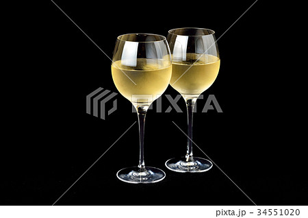 注意 グラスと黒背景に小ゴミやレタッチ痕残ります 白ワインとグラスのイメージ の写真素材