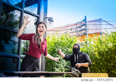 The thief extortion to get woman's handbag. 34552855