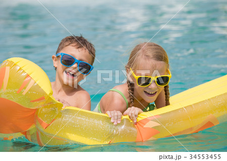Two happy children playing on the swimming pool at the day time. Two happy children playing on the swimming pool at the day time. 34553455