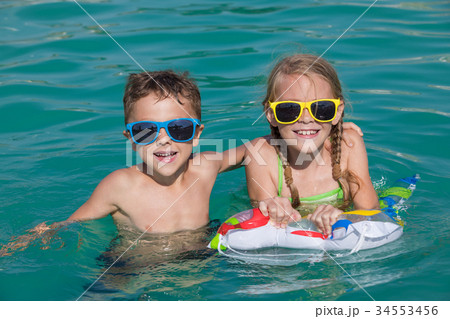 Two happy children playing on the swimming pool at the day time. Two happy children playing on the swimming pool at the day time. 34553456
