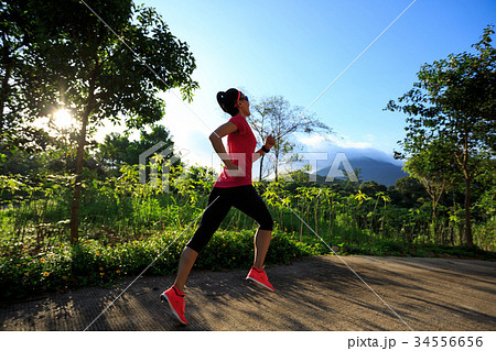 Young fitness woman running at forest trail Young fitness woman running at forest trail 34556656