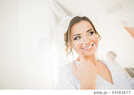 Gorgeous bride in robe posing and preparing for Gorgeous bride in robe posing and preparing for 34563677