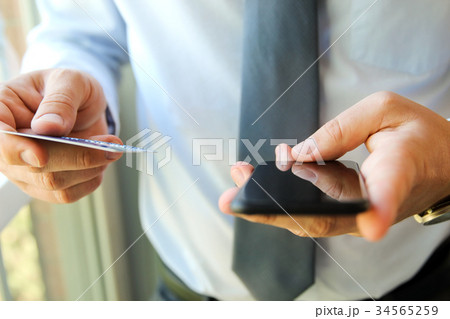 business man entering data of a credit card. 34565259