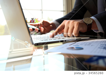Man working and analyzing on a graphs on a laptop 34565260