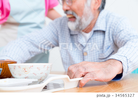 食事　若い看護師もしくは介護士とおじいちゃん　老人ホーム　デイケアセンター 34565327