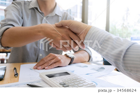business shaking hands in a modern office business shaking hands in a modern office 34568624