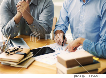 Three confident students reading a book 34568980