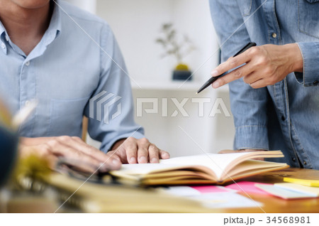 Two asian students doing homework together Two asian students doing homework together 34568981