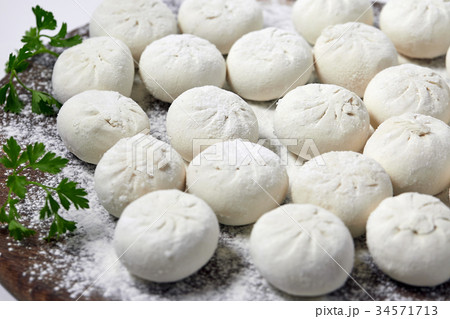 Khinkali on wooden plate with flour. Pelmeni Khinkali on wooden plate with flour. Pelmeni 34571713