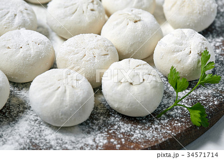 Khinkali on wooden plate with flour. Pelmeni 34571714