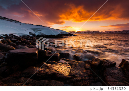 Dramatic sunset on snow-covered coast. Norway Dramatic sunset on snow-covered coast. Norway 34581320