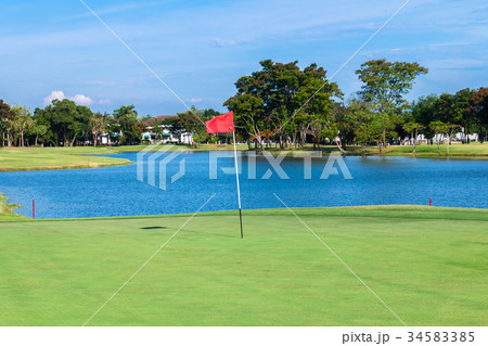 Red flag and sand bunker at golf course Red flag and sand bunker at golf course 34583385