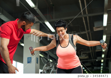 Middle aged woman working out with personal coach Middle aged woman working out with personal coach 34584471