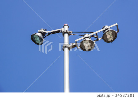 Modern street lamp against the blue sky. 34587281