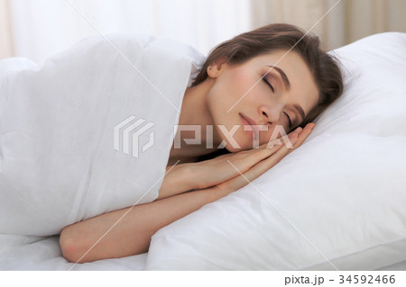 Beautiful young woman sleeping while lying in her Beautiful young woman sleeping while lying in her 34592466