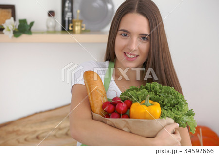 Young caucasian woman in a green apron is holding Young caucasian woman in a green apron is holding 34592666