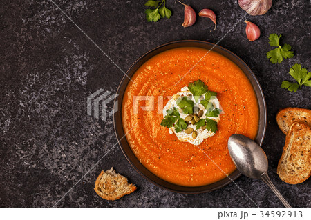 Pumpkin and carrot soup with cream, seeds parsley Pumpkin and carrot soup with cream, seeds parsley 34592913