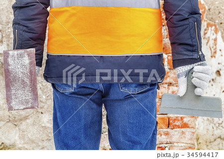 Builder with tools near wall Builder with tools near wall 34594417