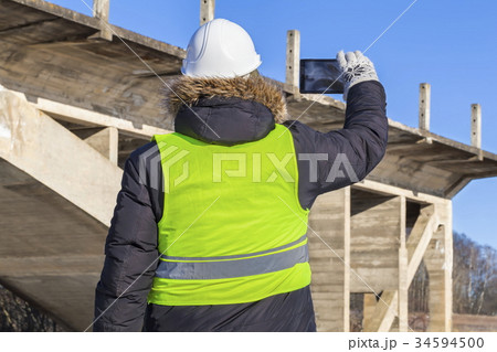 Worker take pictures on tablet near the unfinished 34594500