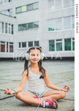 little girl sitting and listening music with 34600445