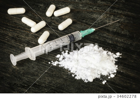 Drugs and syringe on dark table 34602278